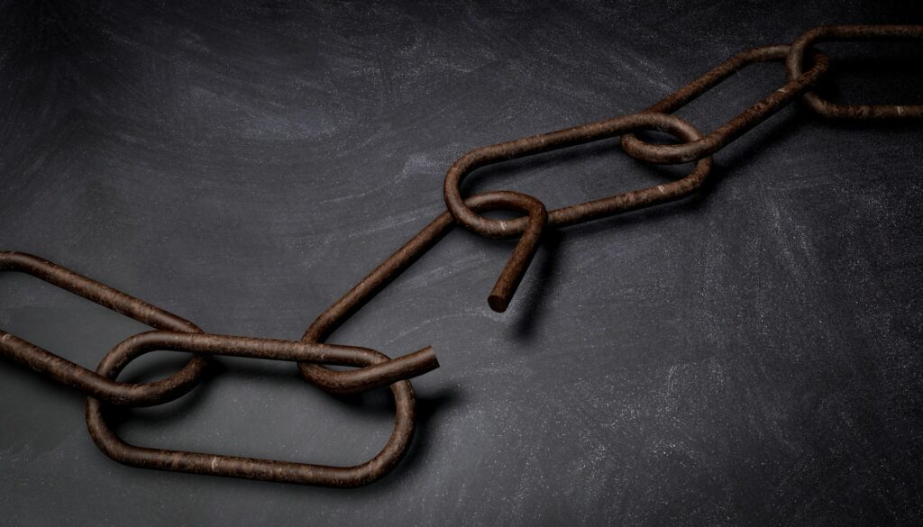 rusty broken chain, on dark stone background